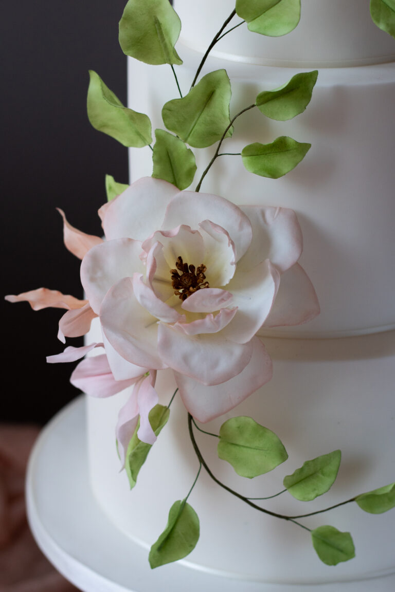 white 3 tier wedding cake with pink heritage rose and clematis with leaf arch-3