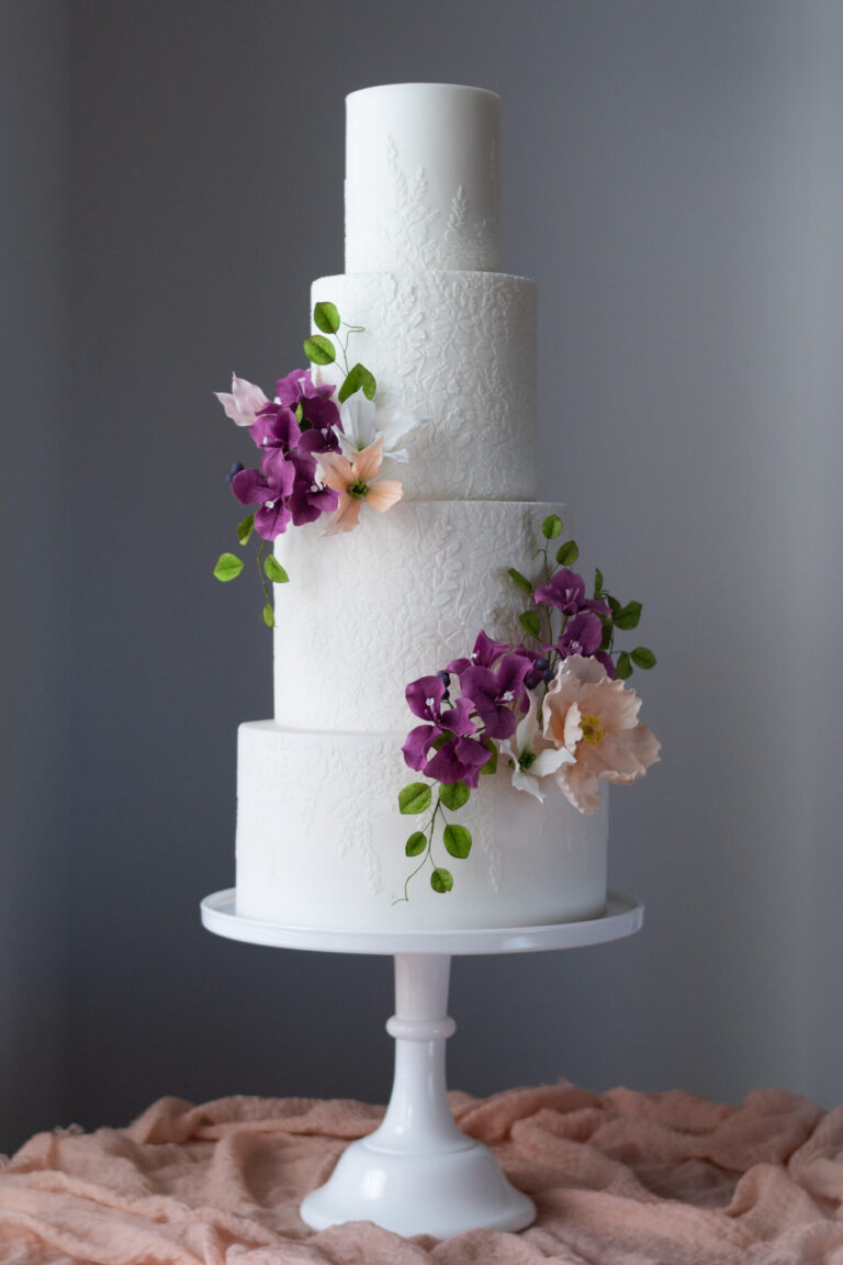 white 4 tier stencilled wedding cake with peach and plum sugar flowers and leaves-1