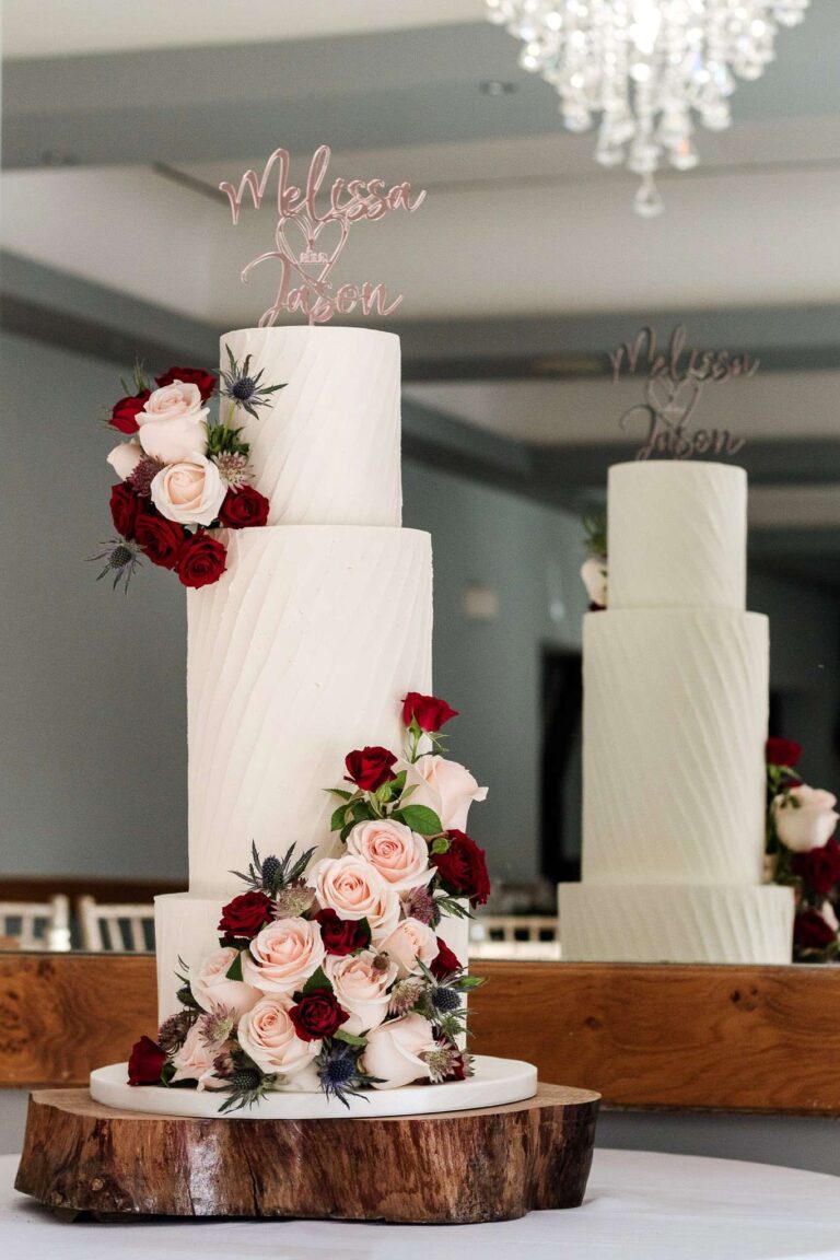 tall 3 tier white rustic wedding cake with flower cascade