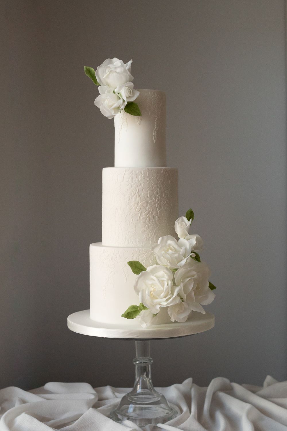 3 tier white floral texture wedding cake with wafer paper roses