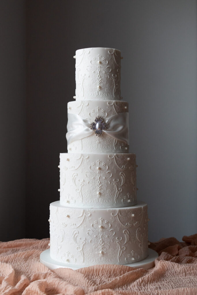 4 tier white stencil and hand piped lace wedding cake