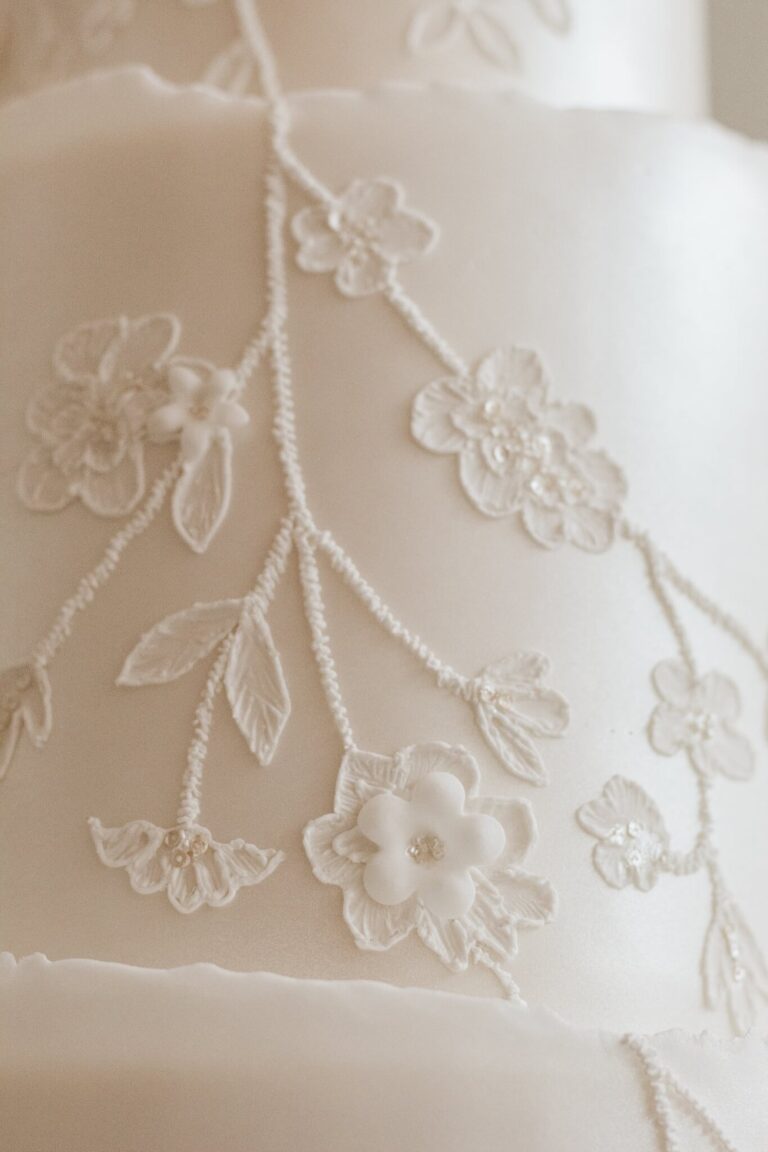 pearl shimmer and piped lace wedding cake detail