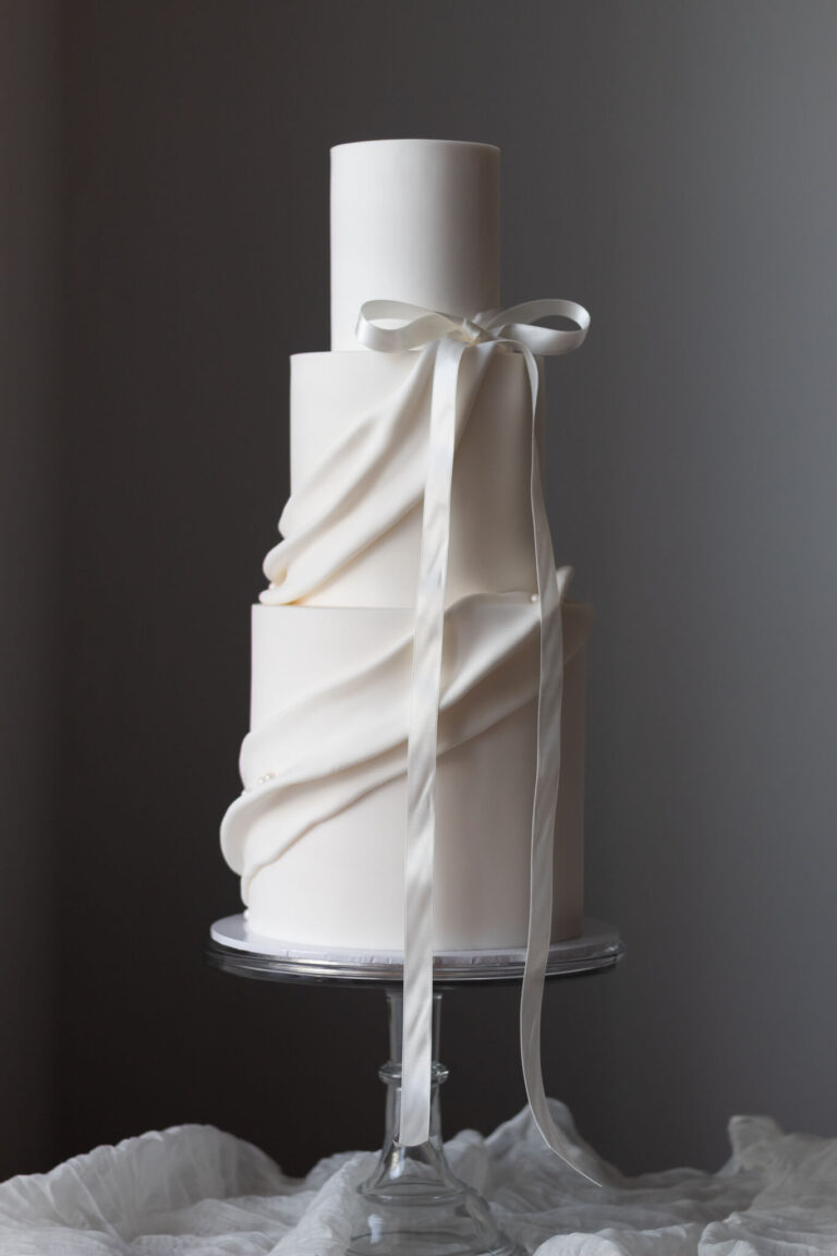 white 3 tier fabric draped wedding cake
