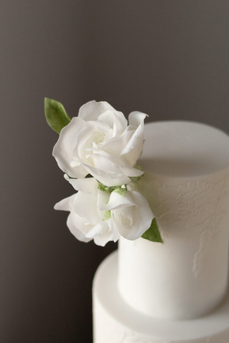 3 tier white floral texture wedding with white wafer roses