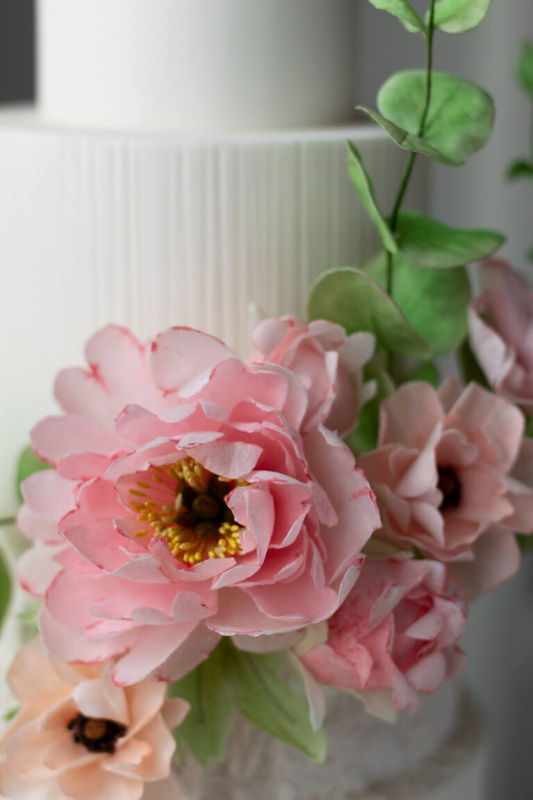 white textured wedding cake with wafer paper peony ranunculus and eucalyptus 9483